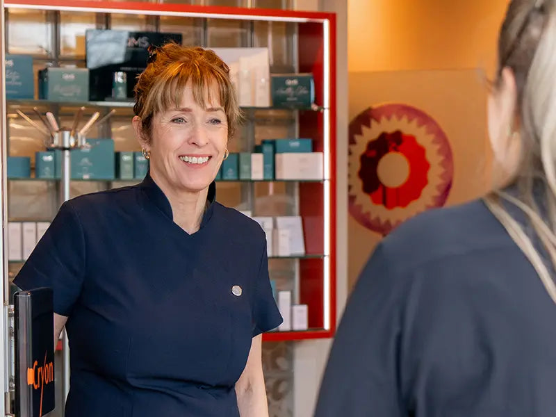 Cryon specialist opent de deur voor een klant bij schoonheidssalon in Breda.